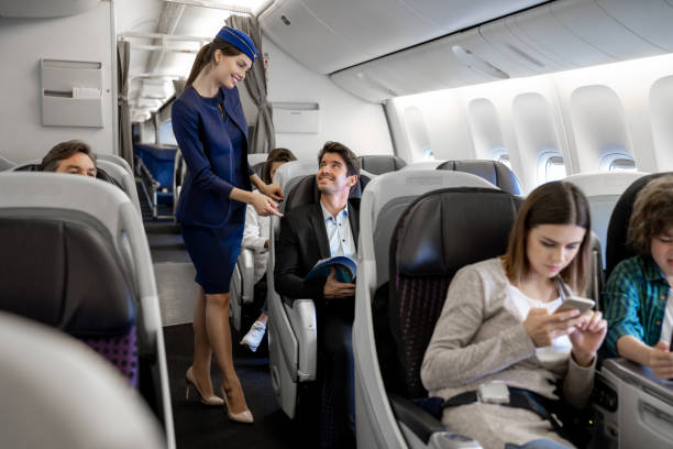 comissária de bordo checando um homem no avião - assistente de bordo - fotografias e filmes do acervo