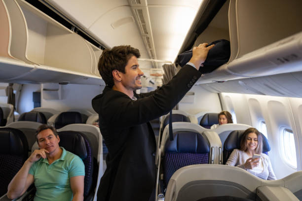 istock Happy passenger putting his carry-on luggage in the overhead compartment 1096223672