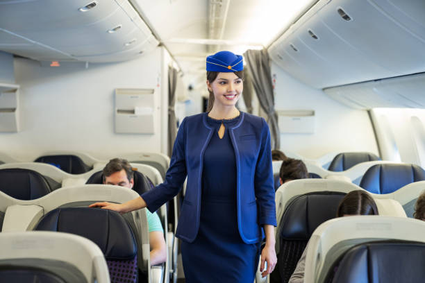istock Friendly flight attendant walking the aisle in an airplane 1096223692