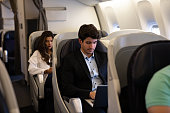 Business man traveling by plane and working on his laptop