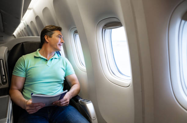 istock Man traveling by plane and reading a magazine 1096223774