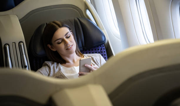 istock Woman traveling by plane and using her cell phone onboard 1096223782