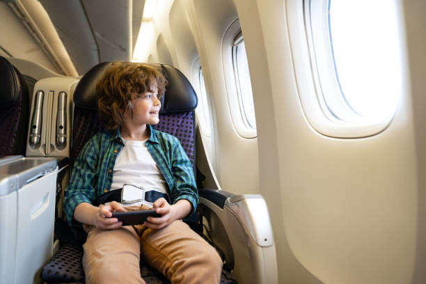 istock Boy traveling by plane and playing games onboard on a mobile phone 1096223790