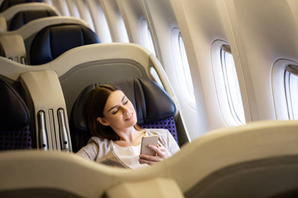 istock Woman traveling by plane and using her cell phone onboard 1096223808