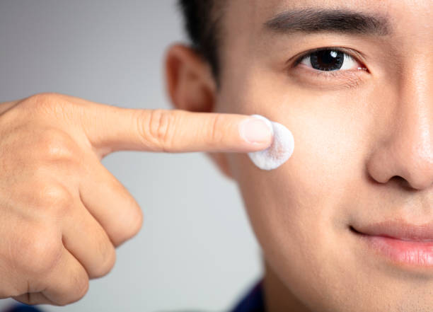 istock closeup young man applying facial cream 1096240998