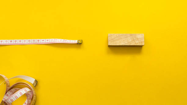 istock Waist circumference with wood block on yellow  background 1096254584