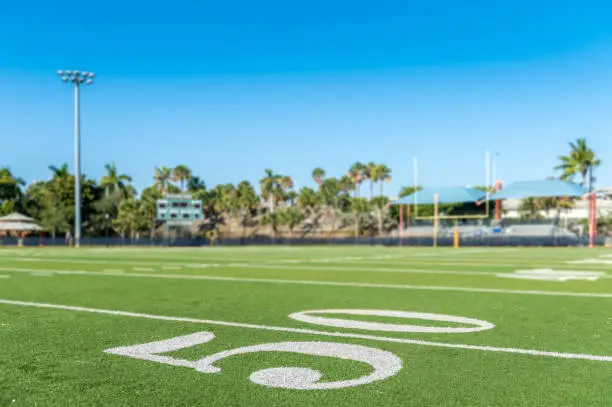 Football stadium 50 yard line artificial grass and markings.