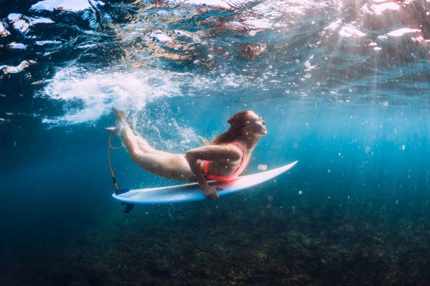istock Surf girl dive underwater with under wave. 1096267534