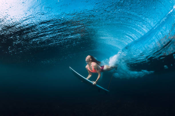 istock Surfer woman dive underwater with under barrel wave. 1096267542