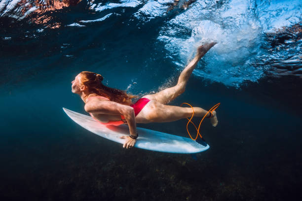 istock Attractive surfer woman dive underwater under wave. 1096267668