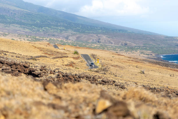 view of piilani highway on the island of maui, hawaii, usa. also known as the back road to hana, the highway leads along mt. haleakala's southern flank. beautiful dry grass, mountain and ocean. - haleakala national park mountain winding road road imagens e fotografias de stock