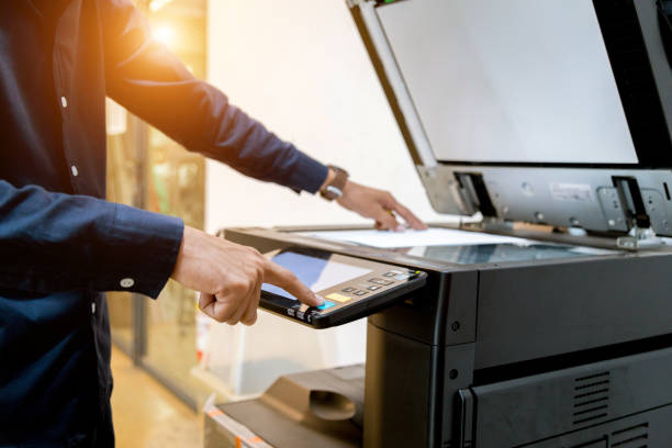 istock Bussiness man Hand press button on panel of printer, printer scanner laser office copy machine supplies start concept. 1096299288