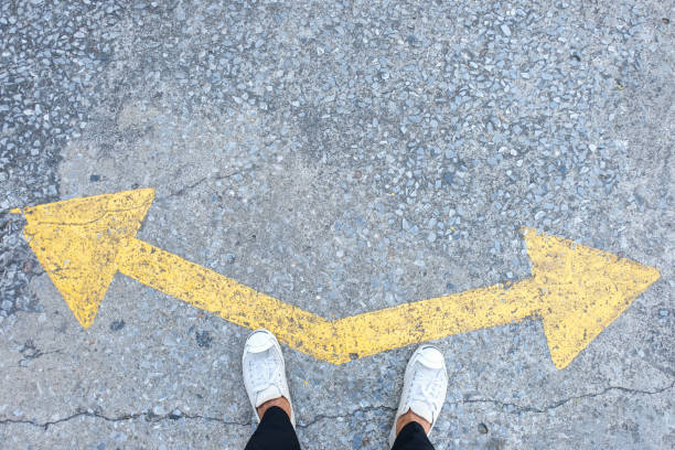 istock Someone wearing sneakers choosing a waymarked with direction arrows choices left or right. 1096299302