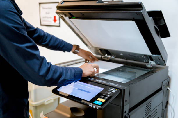 istock Bussiness man Hand press button on panel of printer, printer scanner laser office copy machine supplies start concept. 1096299616