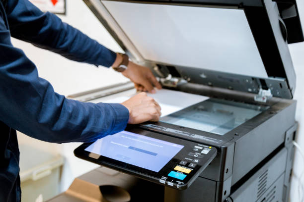 istock Bussiness man Hand press button on panel of printer, printer scanner laser office copy machine supplies start concept. 1096299668