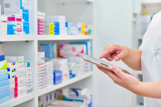 Pharmacist holding computer tablet in pharmacy drugstore stock photo