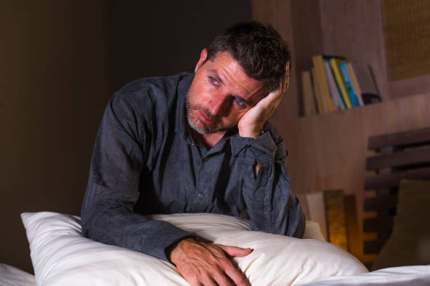 istock young attractive sad and depressed man on bed suffering anxiety crisis and depression problem feeling overwhelmed and stressed late at night on dramatic light in pain emotion concept 1096323312