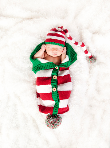 Newborn baby boy wrapped in a Christmas themed crocheted wrap.