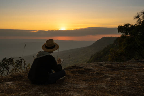 istock Woman sitting  reading and writing looking out at beauitiful natural view 1096339346