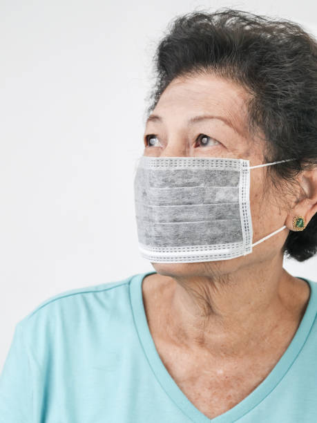 istock Asian senior woman wearing earloop mask on white background. 1096340322