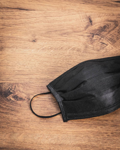 istock Pollution mask on wooden background. Black mask for wearing. 1096351718