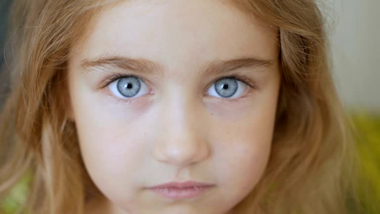 Portrait little young girl with blue eyes looking at camera