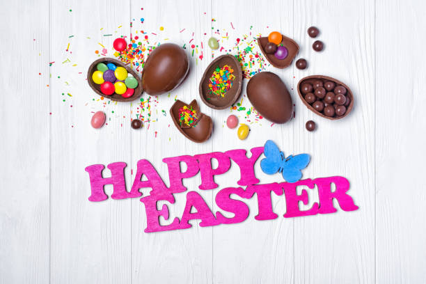 istock Top view on pink text of happy easter and chocolate traditional eggs with bright colorful dragee and sugar sprinkles 1096363774