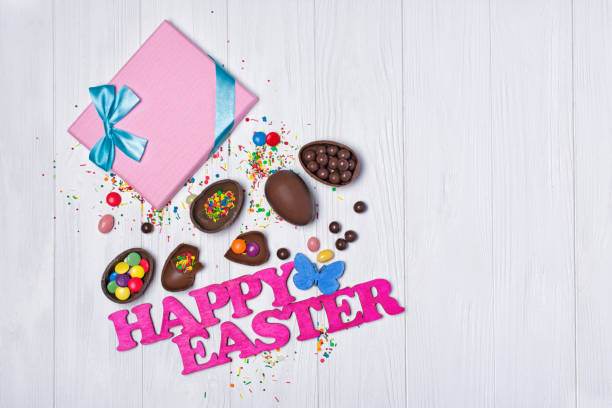 istock Top view on pink text of happy easter and gift box with chocolate traditional eggs and bright colorful dragee 1096363816
