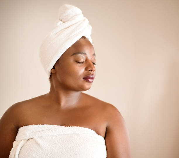 istock Female with towel wrapped on her head against brown background. 1096367186
