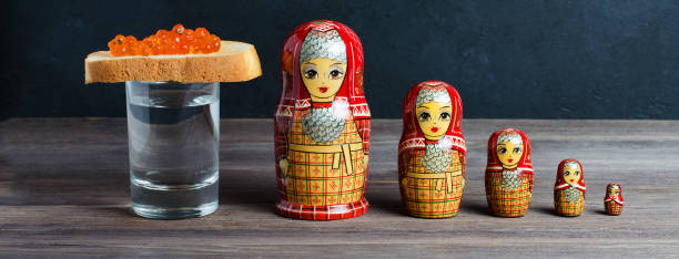 Sandwiches with red caviar of salmon fish. A glass of vodka, matryoshka. The concept of Russian tradition. Sandwiches with red caviar of salmon fish. A glass of vodka, matryoshka. The concept of Russian tradition. slavic culture photos stock pictures, royalty-free photos & images