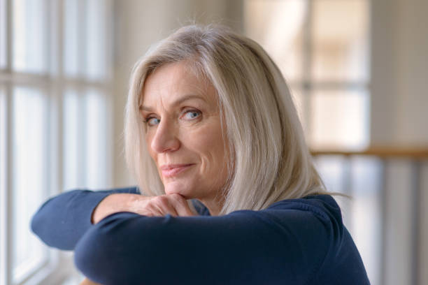istock Attractive blond woman watching through a window 1096376328