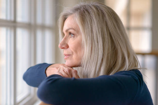 istock Attractive blond woman watching through a window 1096381686