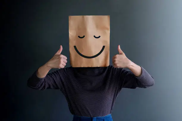 Photo of Customer Experience or Human Emotional Concept. Woman Covered her Face by Paper Bag and present Happy Feeling by Drawn Line Cartoon and Body Language