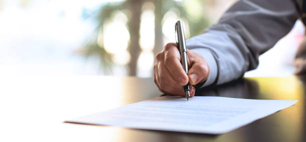 Signing Official Document Businessman Signing An Official Document agreement stock pictures, royalty-free photos & images