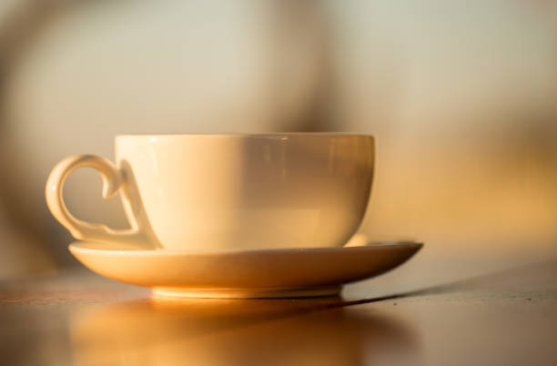 istock coffee cup with sunset background on wood table. 1096396774