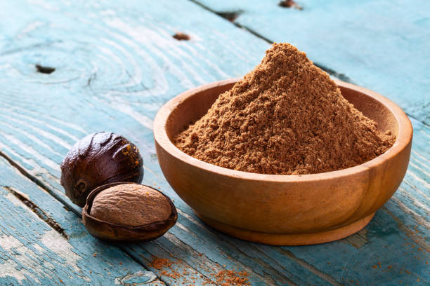 istock Whole inshell nutmeg nuts in a bowl on blue rustic wooden table. 1096400270