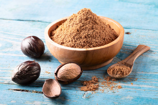 istock Whole inshell nutmeg nuts in a bowl on blue rustic wooden table. 1096401374