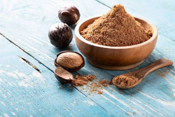 istock Whole inshell nutmeg nuts in a bowl on blue rustic wooden table. 1096402630