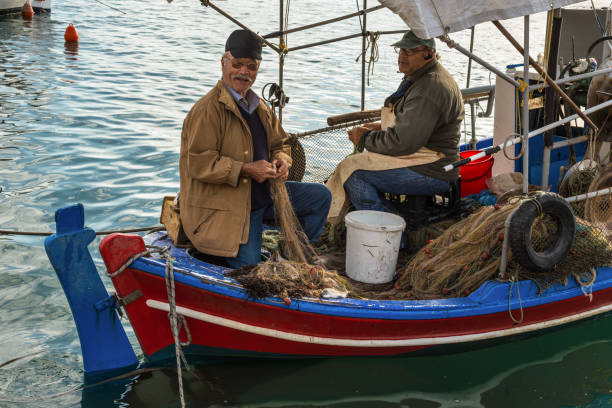 Katakolon, Greece - October 31, 2017: Local fishermen soarting out his nets. Fresh sea food. Catch of the day. Greek local fishermen. Working in the docks on the boat. Aegean lifestyle. seafood. Island life.