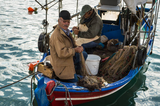 Katakolon, Greece - October 31, 2017: Local fishermen soarting out his nets. Fresh sea food. Catch of the day. Greek local fishermen. Working in the docks on the boat. Aegean lifestyle. seafood. Island life.