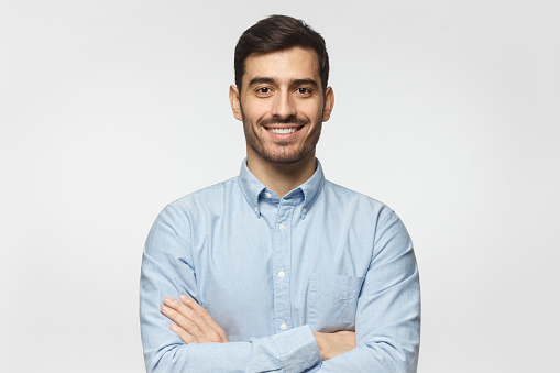 Sonriente hombre de negocios en camisa azul aislada sobre fondo gris photo