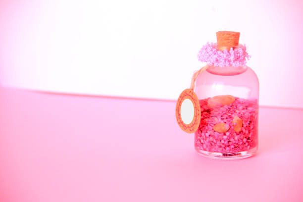 Alchemy and aromatherapy pink background and glass bottle