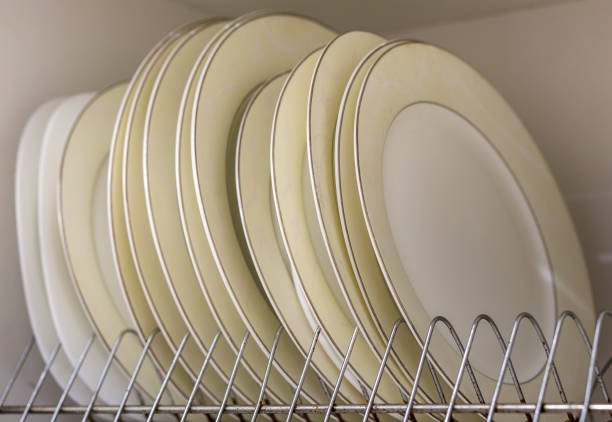 istock Dish drying metal rack with big nice white and light yellow clean plates on blurred background. Traditional comfortable kitchen. 1096449014