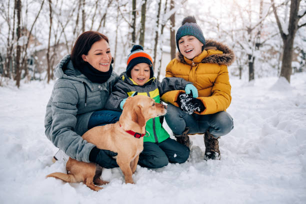 istock Family with dog playing in the snow 1096454838