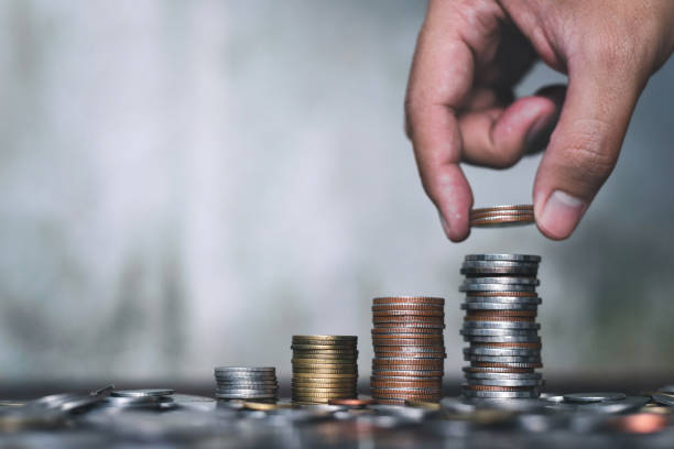 istock Save money concept with hand holding coin and stack growing business on abstract background 1096454846