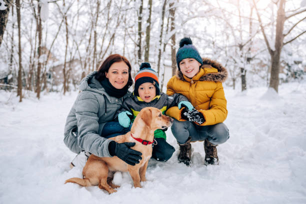 istock Family with dog playing in the snow 1096454880