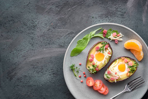 istock Keto diet dish: Avocado boats with ham cubes, quail eggs, cheese on dark with copy-space 1096460700