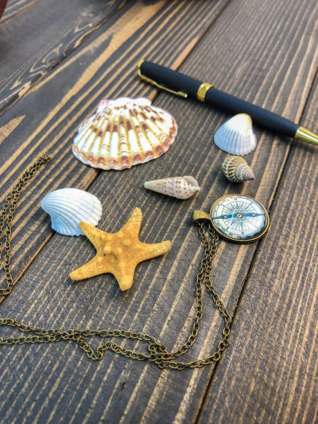 istock seashells, starfish, pen and clock lie on a wooden table 1096460722