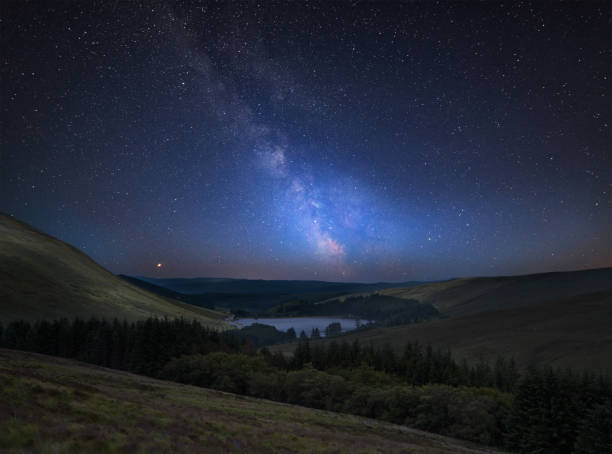 Vibrant Milky Way composite image over landscape of mountains in distance stock photo