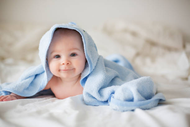 istock Cute little baby boy, relaxing in bed after bath, smiling happily 1096476366